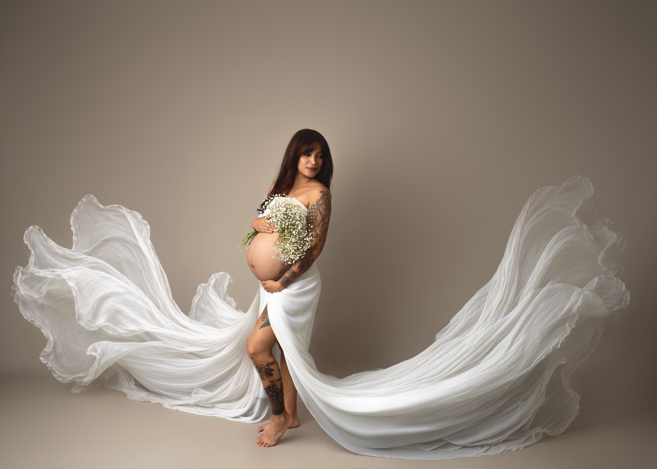 Maternity photography Appleton WI - woman in flowing white fabric gown, dramatic studio portrait