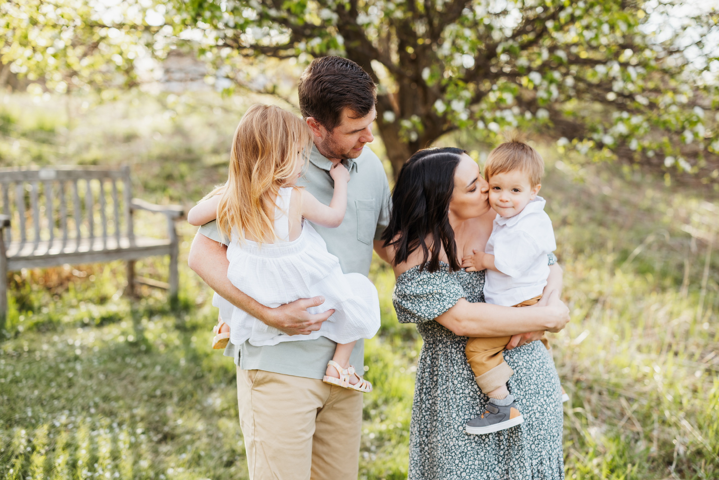 Family photography Appleton WI, parents holding two young children outdoors