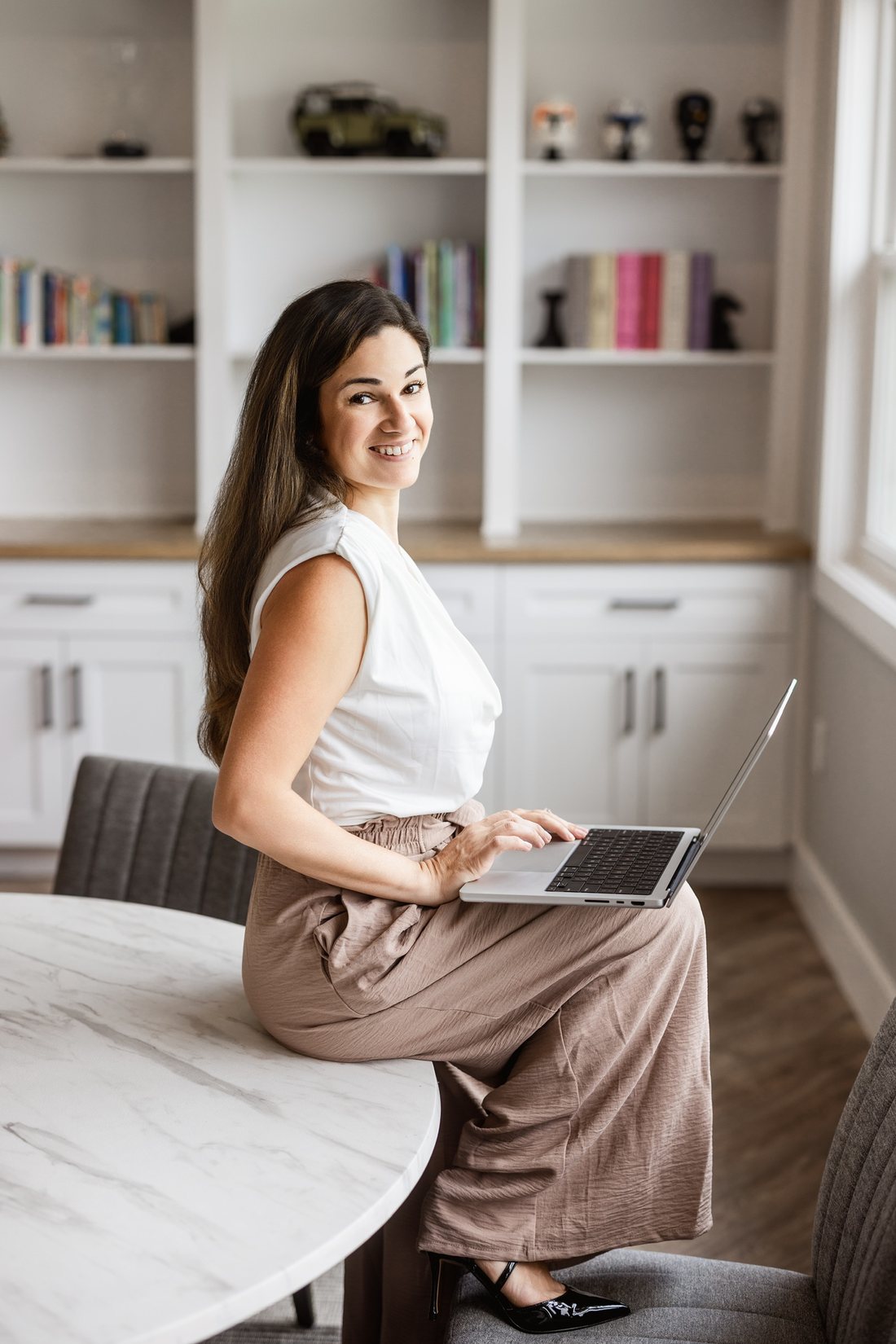 Business owner seated at a bright marble counter with a tablet