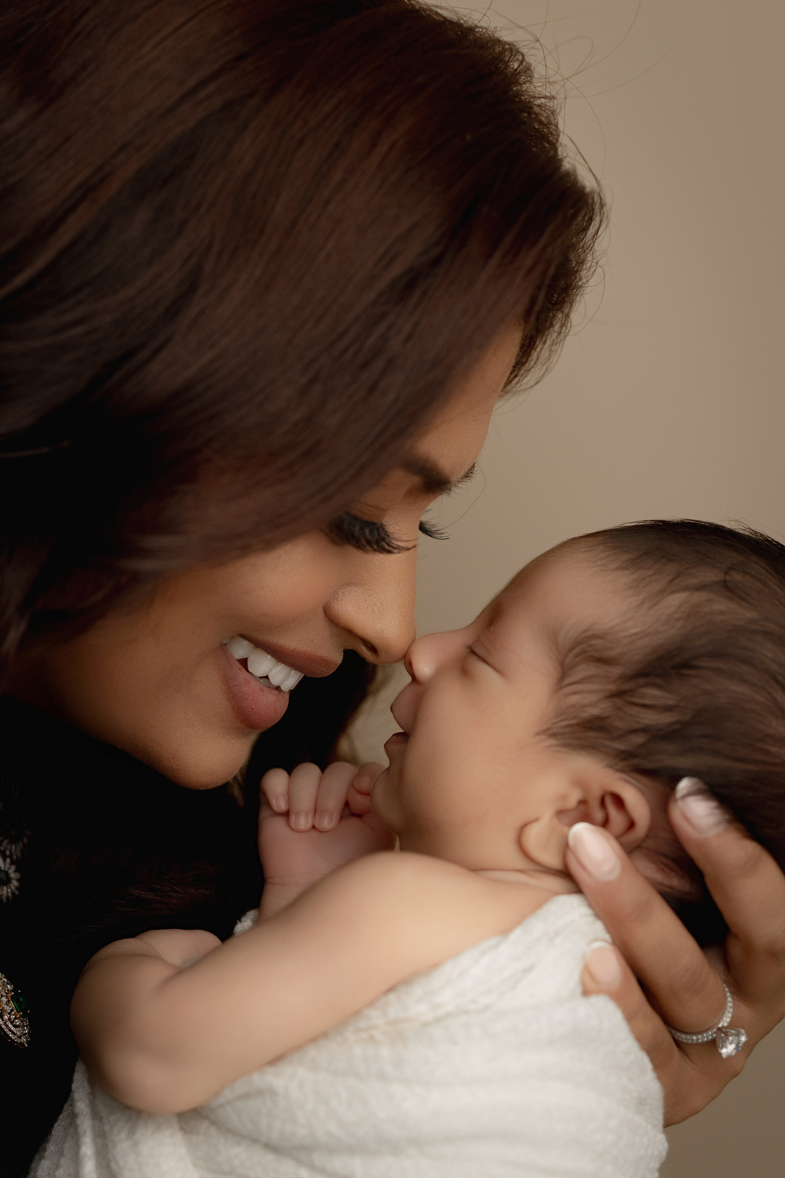 Mother smiling nose to nose with her newborn during a studio session